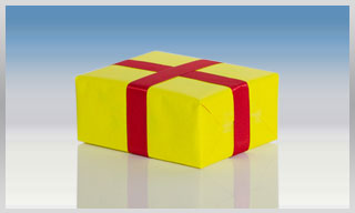 Paket in gelben Packpapier eingeschlagen mit rotem Band